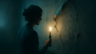 A candlelit Victorian room with a small patch of yellow wallpaper peeled back to reveal damp plaster beneath